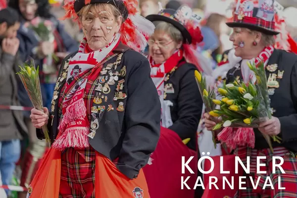 Kölsch Madel in bunten Kostümen, verteilen Tulpen während des Rosenmontagsumzugs, neben dem Bildtitel "Kölner Karneval"