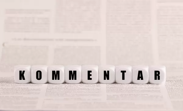 Kommentar, Würfel, Holzwürfel auf Zeitungspapier