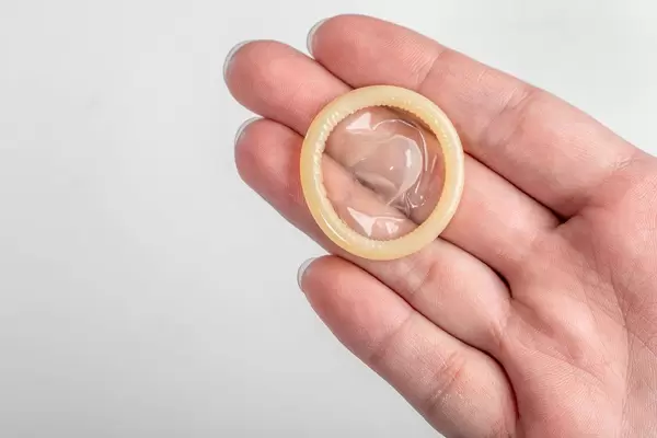 Kondom ohne Verpackung auf der Hand eines Mannes