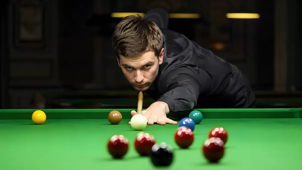 Konzentrierter Snookerspieler beim Stoß am grünen Tisch