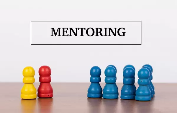 Konzept von Beratung und Consulting dargestellt mit Spielfiguren und Text MENTORING