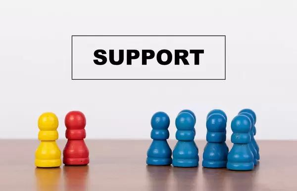 Konzeptbild Unterstützung, symbolisch dargestellt mit Bauernfiguren auf einem Tisch