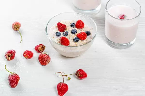 Konzeptbild zum Thema gesundes Frühstück: Haferflocken mit Erdbeeren, Blaubeeren und Joghurt im Glas