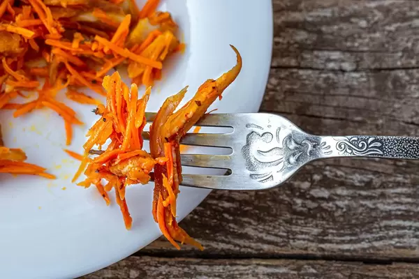 Koreanische Karotten mit Stücken von geräucherten Schweinefleischohren in Nahaufnahme