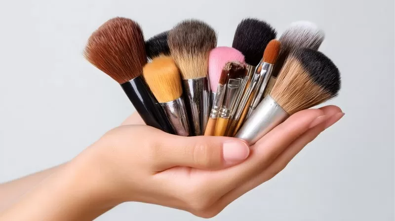 Kosmetikpinselset in zwei Händen gehalten isoliert