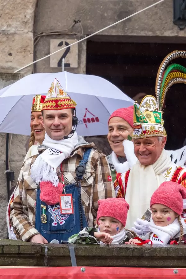 Kostümierter Zugleiter Holger Kirsch steht neben dem Dreigestirn am Severinstor in Köln