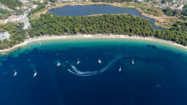Koukounaries lagoon and peninsula with pine forest separating the lagoon from Chrysi Ammos beach