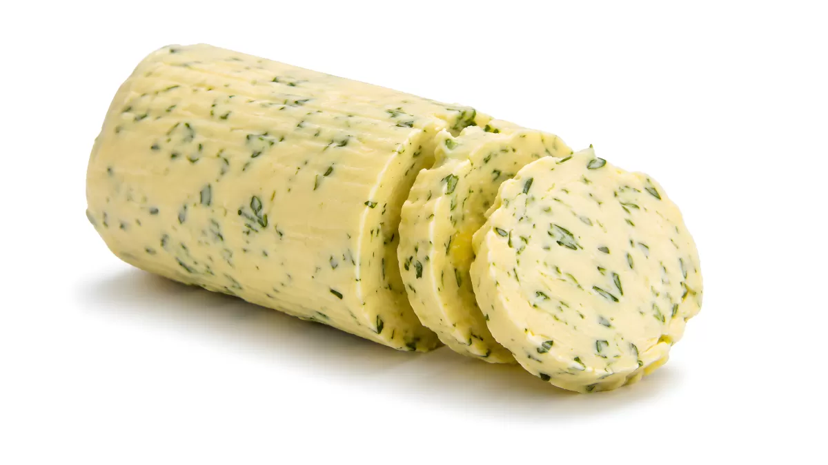 Kräuterbutter-Rolle mit frischen Kräutern aufgeschnitten
