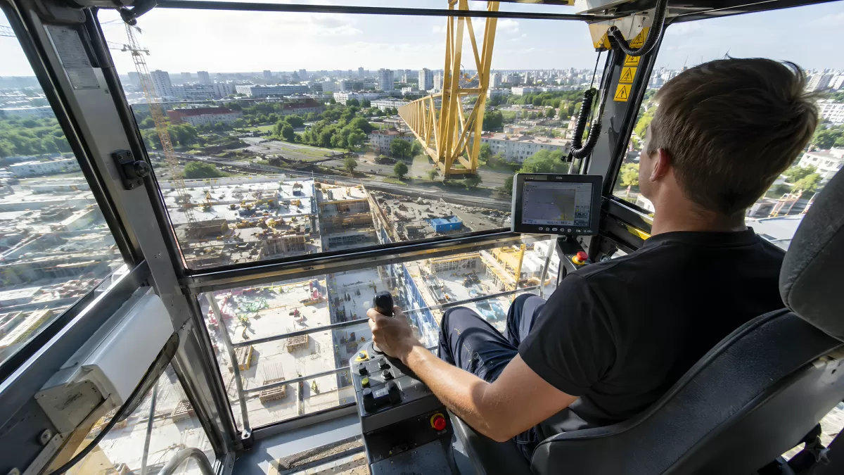 Kranführer in der Kabine mit Blick auf Baustelle