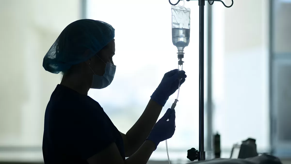 Krankenpflegerin bereitet Infusion am Tropf vor