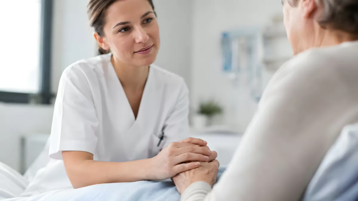 Krankenschwester hält die Hand einer Seniorin