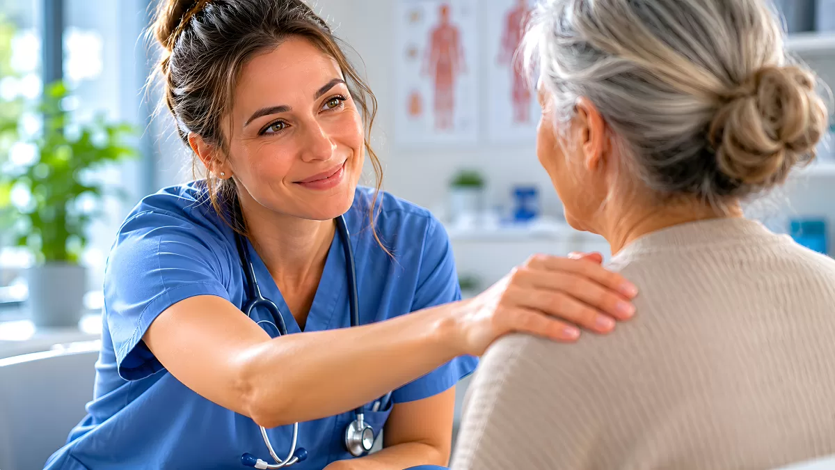 Krankenschwester legt tröstend Hand auf Schulter älterer Patientin