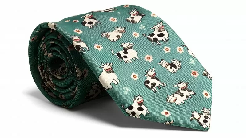 Krawatte mit lustigem Kuhmuster auf grünem Hintergrund