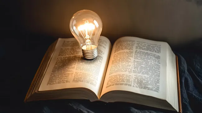 Kreative Idee durch Wissen - Glühbirne auf Buch