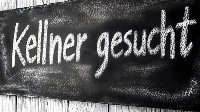 Kreide-Schriftzug 'Kellner gesucht' auf rustikalem Holz