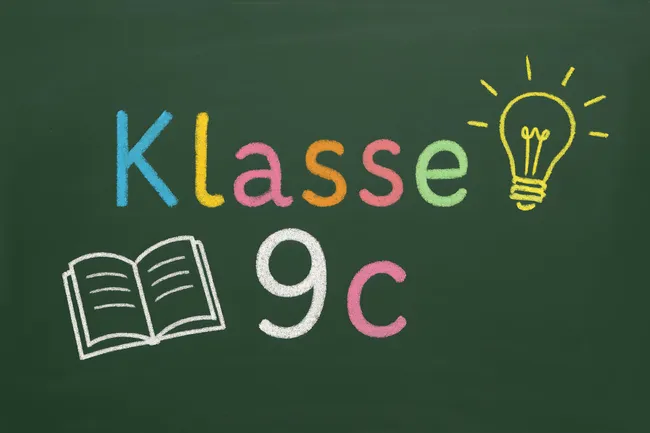 Kreide-Tafel mit Klasse 9c und Symbolen für Schule und Bildung
