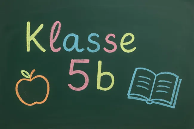 Kreideaufschrift für Klasse 5b mit Apfel und offenem Buch