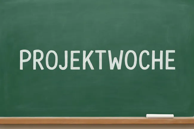 Kreideaufschrift 'Projektwoche' auf grüner Tafel