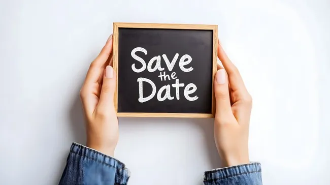 Kreidetafel mit Ankündigung 'Save the Date' in Frauenhänden