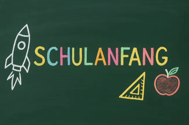 Kreidezeichnung zum Schulanfang mit Rakete und Apfel