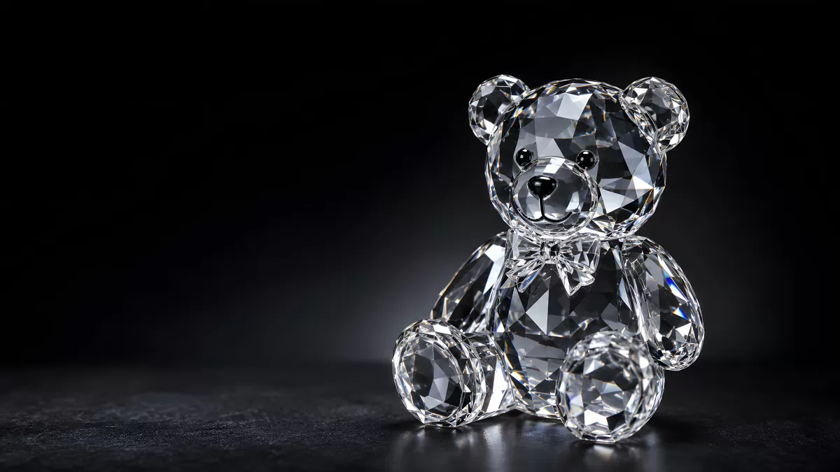 Kristallbär aus Glas mit Schleife auf dunklem Hintergrund
