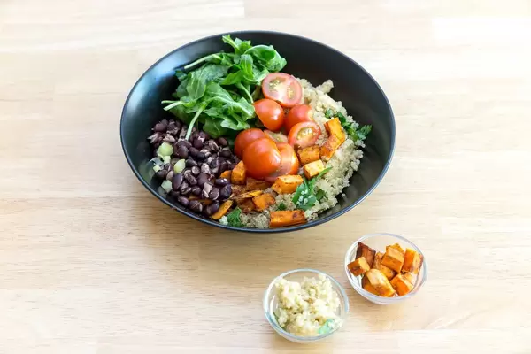 Kubanische Quinoa-Bowl mit Quinoa und gebratenen Süßkartoffeln in kleinen Glasschüsseln