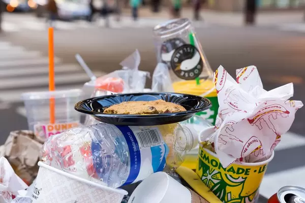 Kuchen im Teller auf einem Müllhaufen