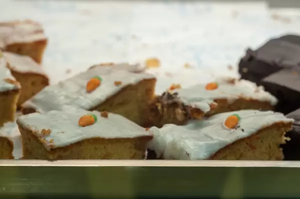 Kuchen mit weißer Zuckerglasur und kleinen Karotten aus Fondant oben drauf