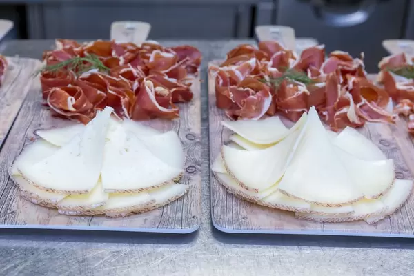 Küchenbretter mit dünnen Scheibchen von Käse und Rohschinken