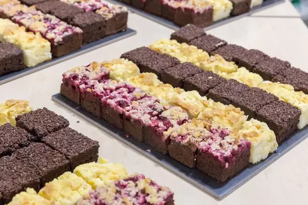 Kuchenstücke in mundegerechter Größe - Apfel-Streuselkuchen, Pflaumen und Schoko-Kuchen an einem Buffet