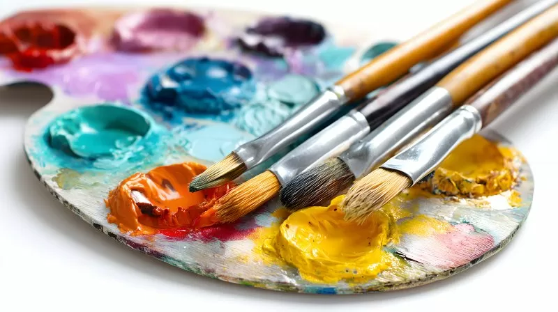 Künstlerpalette mit Ölfarben und Pinseln auf weißem Hintergrund