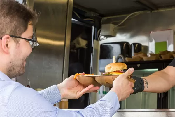 Kunde nimmt seinen veganen Cheeseburger entgegen