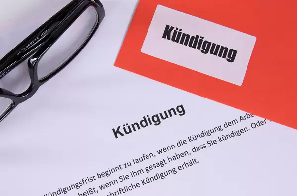 Kündigung document with glasses and red envelope