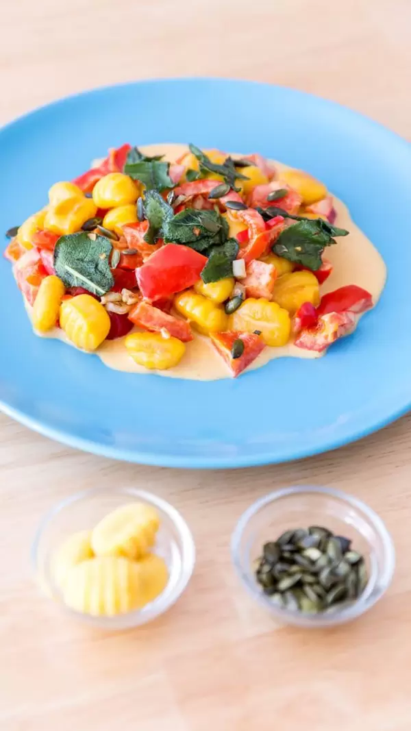 Kürbisgnocchi in Paprikasoße mit Gnocchi und Kürbiskernen in kleinen Schalen