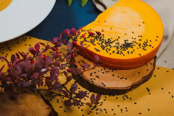 Kürbisscheibe mit kleinen schwarzen Samen bestreut