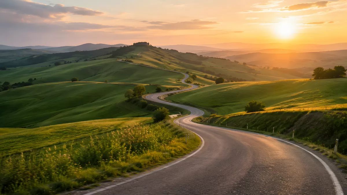 Kurvenreiche Straße durch grüne Hügel beim Sonnenuntergang