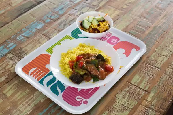 Kuskus mit Fleisch, Melanzani und Paprika und ein Salat mit Gurke, Bohne und Mais