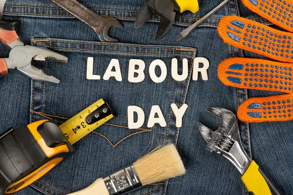 Labor day background with tools on jeans backdrop
