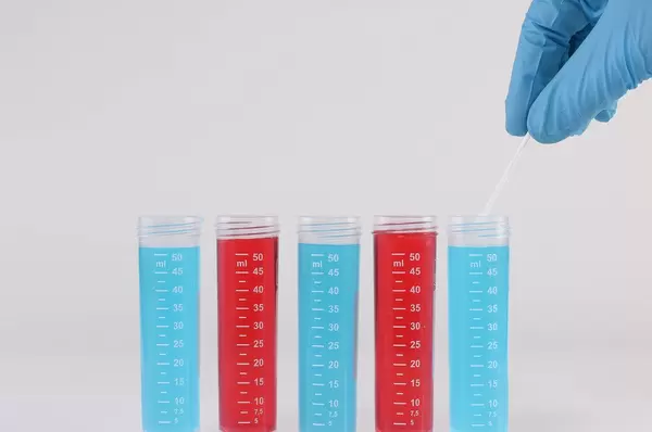 Laboratory assistant collecting samples for analysis on white background