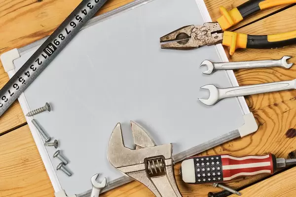 Labour day background with different working tools placed around the whiteboard