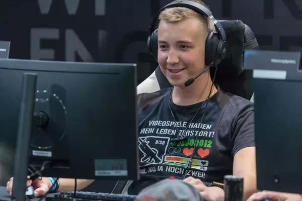 Lächelnder Gamer mit lustigem T-Shirt auf der Gamescom 2018