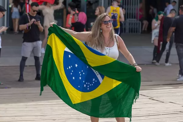 Lachende Festivalbesucherin am Tomorrowland 2019 hält Flagge von Brasilien