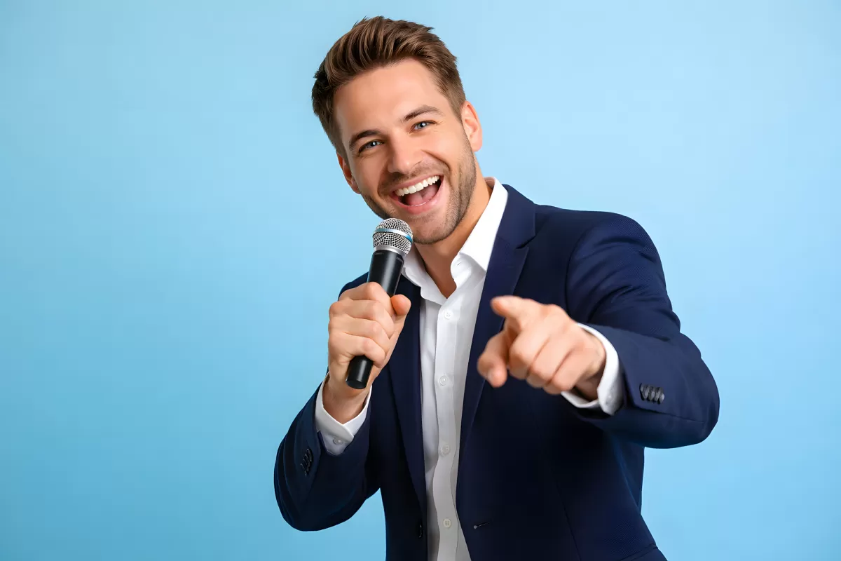 Lachender Geschäftsmann hält Mikrofon und zeigt auf Betrachter