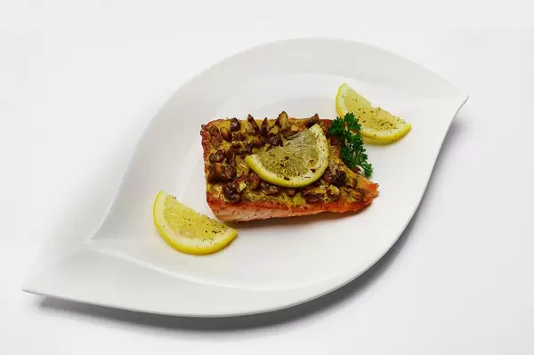 Lachsfilet überbacken mit Käse und gehackten Walnüssen, mit Kräutern und Zitronenscheiben