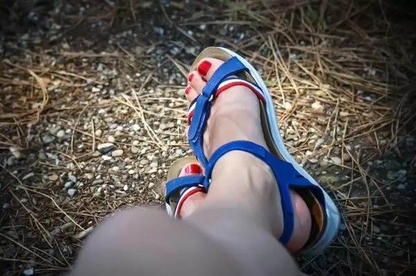 Lackierte Fußnägel in Sandalen