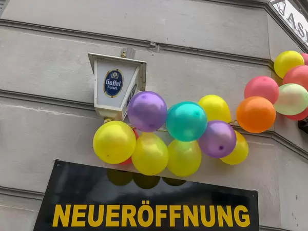 Laden feiert Neueröffnung mit Luftballonkette und Gaffel Kölsch Bier