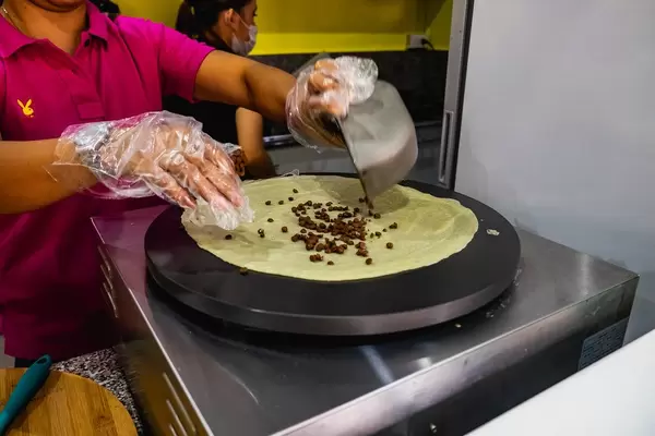 Lady preparing to cook a chocolate crepe (Flip 2019)