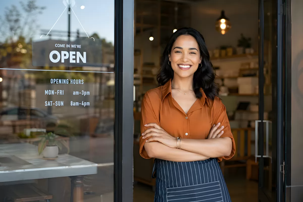 Lächelnde Café-Besitzerin steht stolz in ihrer Tür