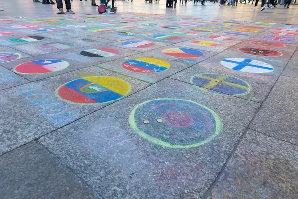 Länderflaggen auf dem Pflaster vor dem Kölner Dom dienen als Spendenaktion