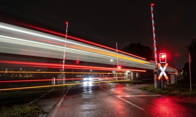 Langzeitbelichtung eines Bahnübergangs bei Nacht